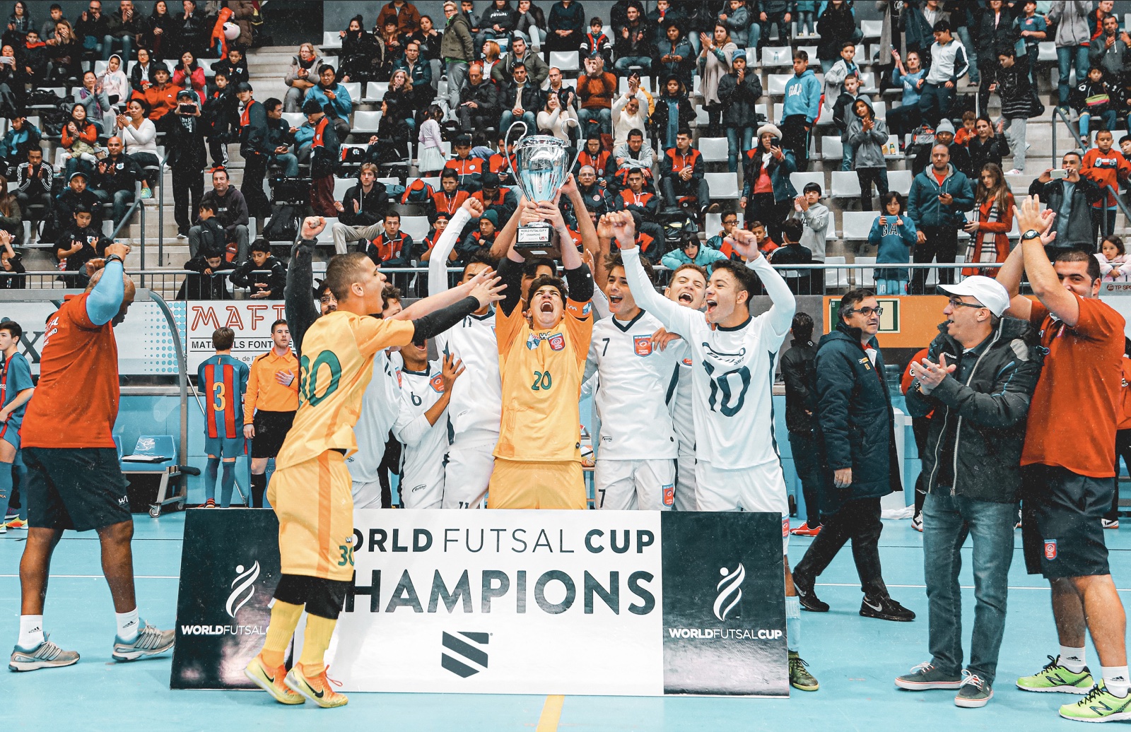 World Futsal Cup champions lifting the trophy in front of a packed crowd